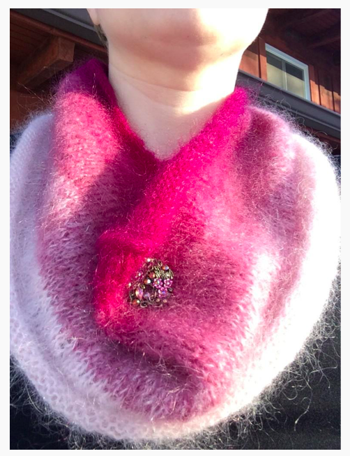 Elyse's pink fluffy cowl with a big sparkly button on it