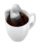 Mr Tea infusing tea with his arms hanging off the mug edge and his legs in the tea - he has a huuuuuge smile on his face, too maybe he's peeing in your tea