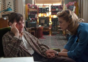 Cumberbatch looking sweaty and disheveled, and a dressed and elegant Knightly comforting him