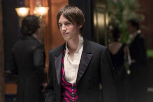Dorian Grey from Penny Dreadful with long ish straight hair in his face and a pink and black striped waistcoat