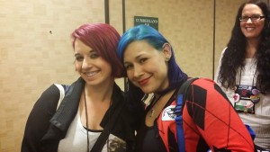 Two girls in line, one with burgundy hair, one with blue as in vibrant blue, hair