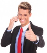 Douchey-grinning business man showing thumbs up while talking on the phone