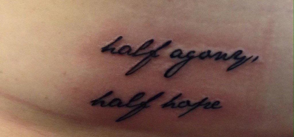 A quote tattoo from Pride and Prejudice that says, "Half agony, half hope" in script.