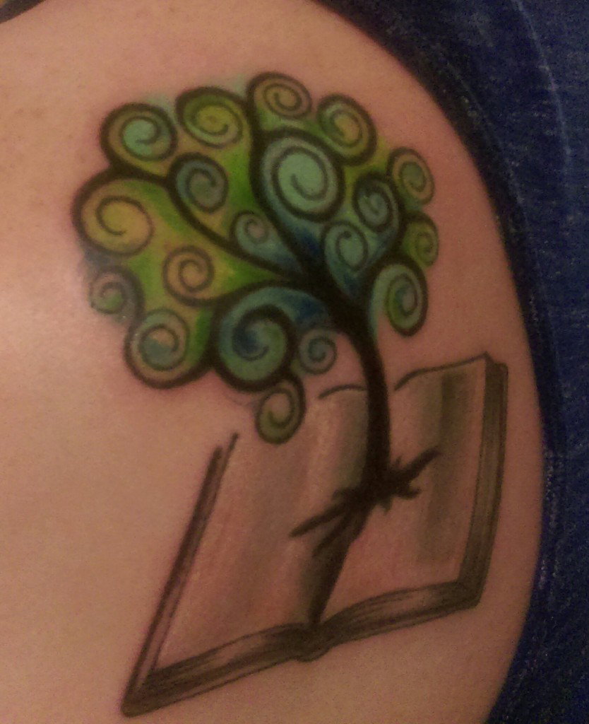 Tree of life tattoo that grows out of a book.