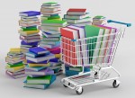 Stacks of colorful books next to a shopping cart