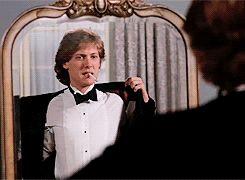 James Spader pulling on a tux jacket, cigarette dangling from his mouth again