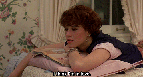 Molly Ringwald laying on her bed saying I Think I'm in Love