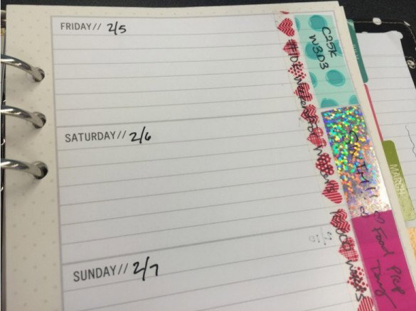 A close up of a planner page with about 8 lines for each day and brightly colored tabs on the side for different topics