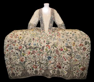 Mantua or dress with panniers like holy smoke. They're at least three feet on either side of the waist of the dress, and every surface is covered with colored embroidery of birds and trees and more birds and it's just jaw dropping
