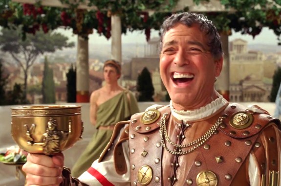 Hail! George! Clooney! Wearing a roman leather toga, holding a goblet and wearing a giant goofy grin