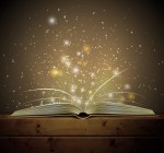 Open book with light and sparkles floating up from the pages.