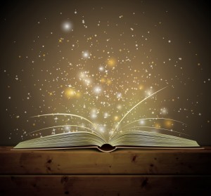 Open book with light and sparkles floating up from the pages.