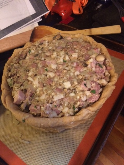 Pie completely filled, including the top layer of forcemeat. The forcemeat is sort of malleable and squishy while the filling has large chunks of meat. 