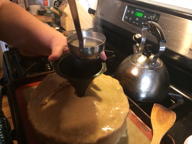 Filling the pie with broth - RedHeadedGirl held a funnel partially inserted into the pie and ladled beef into the pie