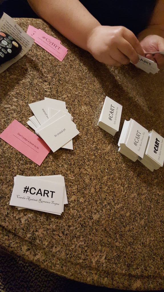 A shot of the table of cards all of us playing Cards Against' Romance Tropes
