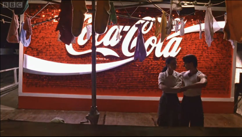 Scott and Fran dancing in front of a large Coca Cola sign