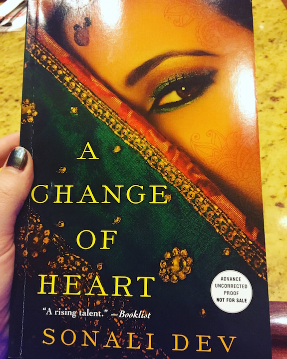Close up of the cover for A Change of Heart by Sonali Dev, which features a diagonal green sari across the lower half of the cover and a woman's eye above the edge of the veil