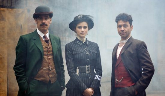 Michael Weston, Rebecca Liddiard, and Stephen Mangan in costume - Liddiard's police uniform is pretty kickass. A pinstriped dress with a cinched waist and a blue feathered hat.