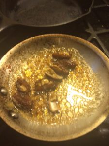 Frying in honey, with the honey all foamy and bubbly and the dates rolling around in it