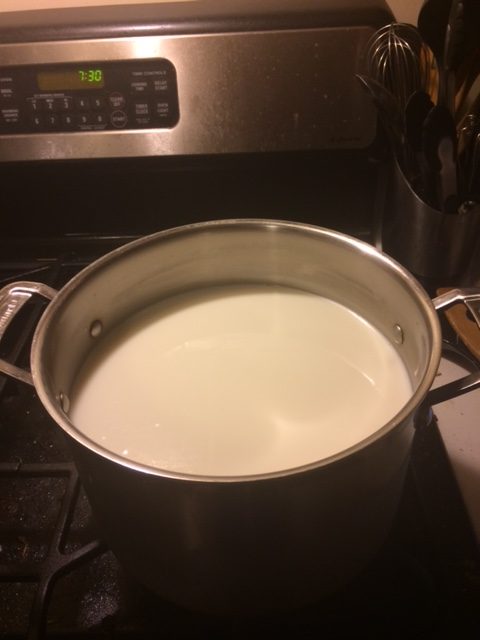 Heating the milk in a large pan on the stove 