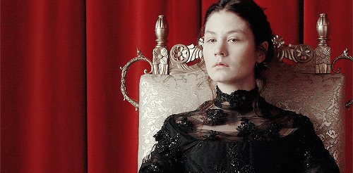 Queen Kristina is stone-faced and unamused on her throne, and yet her resting facial expression is compelling because of one subtle jaw flex that betrays emotion.