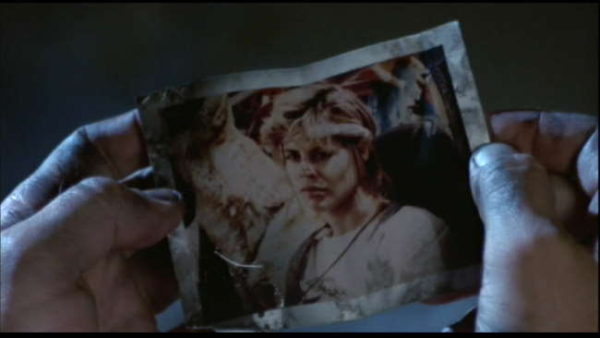 Reese holding the photo of Sarah, who looks sad but resolved.