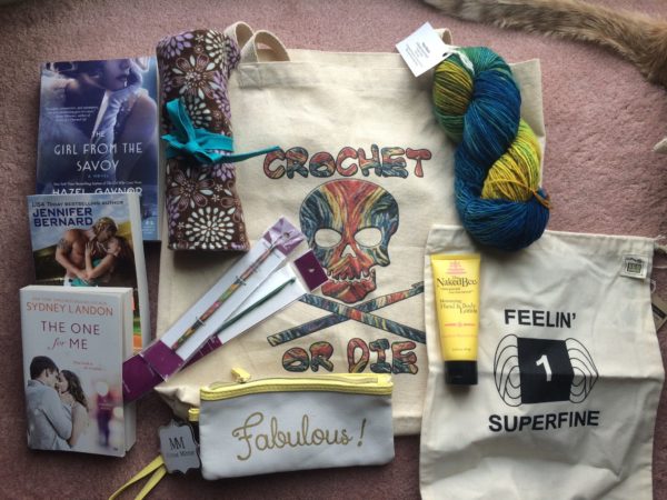 Close up of giveaway contents: Bag, needles, books, yarn and hand cream