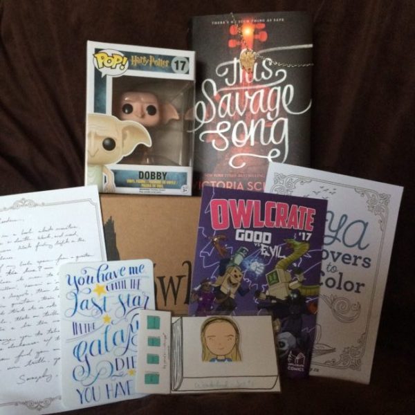 July crate: A dobby funco pop some cards This Savage Song and some other printed material