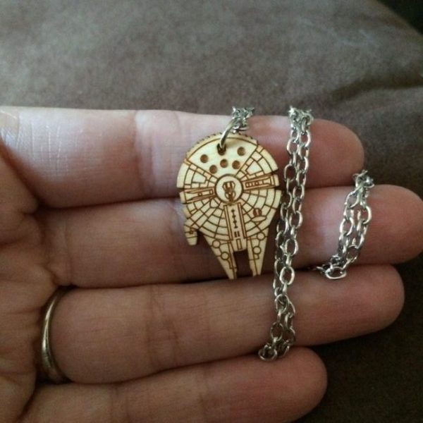 close up of laser carved wood Millennium Falcon necklace on a silver chain