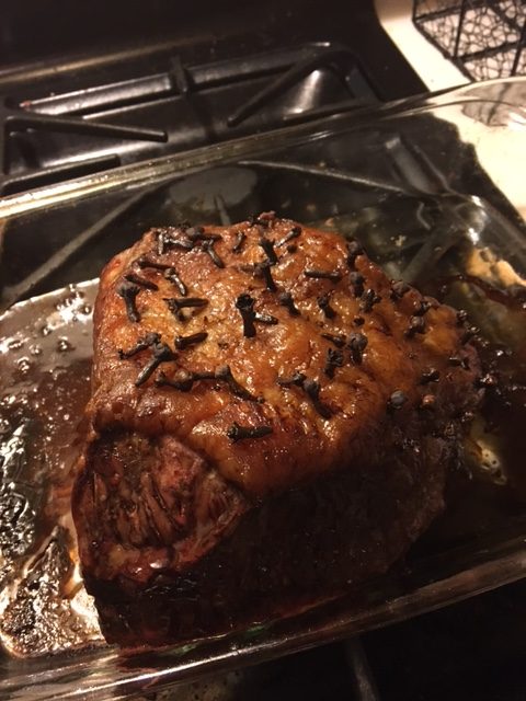 Roast beef with cloves in the fat cap browned and cooked in a baking dish 