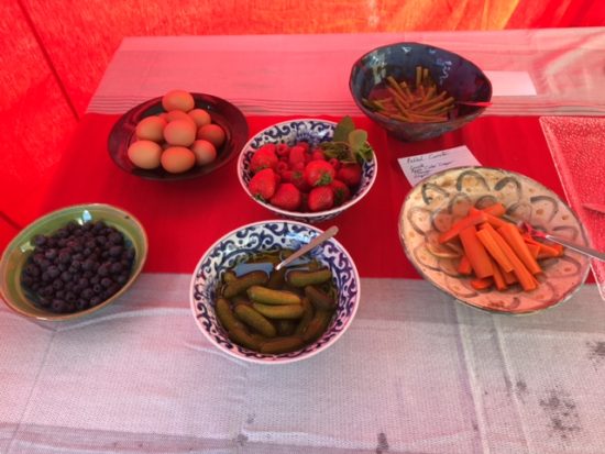 table with bowls of pickled vegetables fruit and eggs 