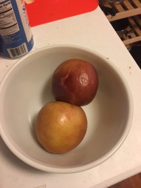 Roasted apples! Theyre sort of dark red and brown and in a white bowl.