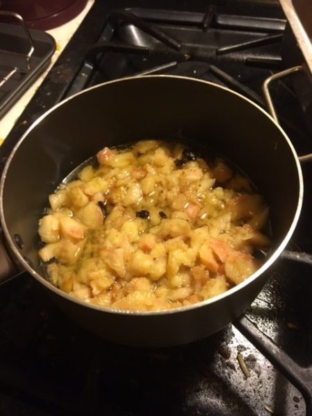 boiling the apples, vinegar, and cranberries in a medium saucepan 