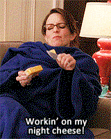 Tina Fey is sitting on her couch, bundled up in a blue snuggie, eating a block of cheese. She's singing "Workin' on my night cheese!" Basically this is how all people from Wisconsin relax.