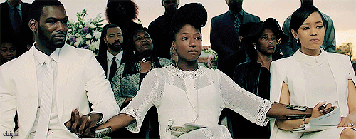 The three leads holding hand wearing white at the funeral. 