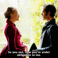 Caro and Enys, facing each other in profile, while she sasses that he's now under obligation to her.