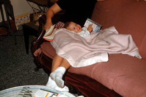 A baby with a romance novel with a big grin on her face