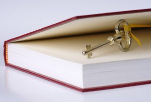 Red covered book with a small brass key holding the cover open 