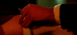 Ross' hand, tying the garter on D's leg. 