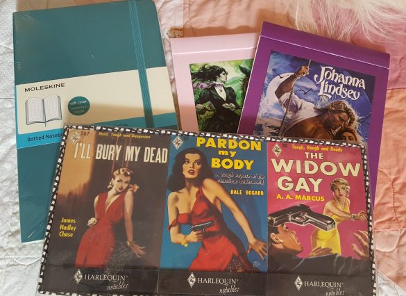 A blue Moleskine notebook, three matchbook style notebooks and two larger cover notebooks