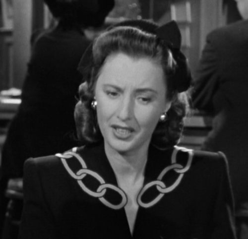 Elizabeth's dark-colored dress with chain-looking trim on the collar.