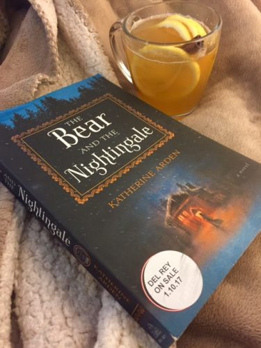 A copy of The Bear and the Nightingale with a fleece blanket and a steamy mug of Frost's Thaw