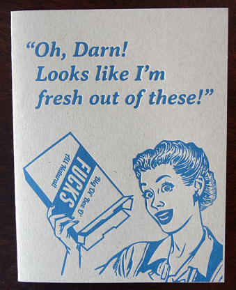 Blue letterpress card with a woman saying Oh Darn look slike I'm fresh out of these while holding a box that says big ol box of FUCKS 