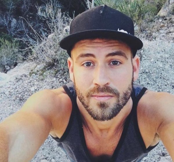 NIck is taking a selfie of himself in a tank top, arm mucles exposed, douchery on display.