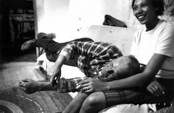 LIFE photograph of the couple on a couch - he is laying down with his head on her lap, and she's laughing and holding a cigarette