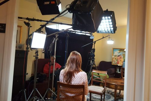 Faith Salie with her back to the camera doing lighting tests