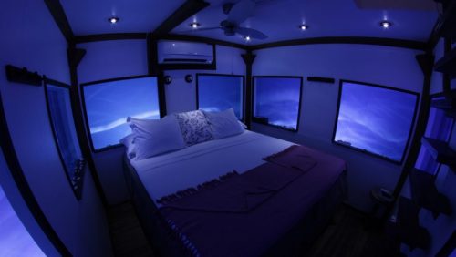 the underwater room at night with small lights in the ceiling and blue everywhere