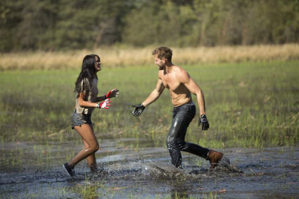 A shirtless Nick chases Raven through the mud.