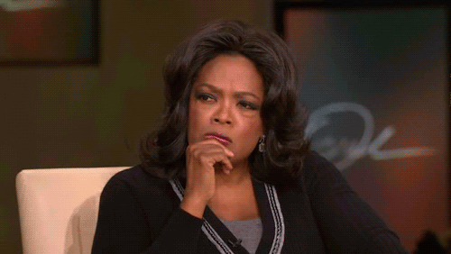 Oprah rests her chin on her hand, her expression clearly one of WTF