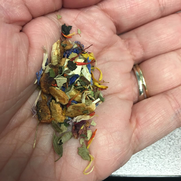 I have some of the loose tea in the palm of my hand. There's orange, yellow and cornflower blue pieces. It looks very pretty and colorful